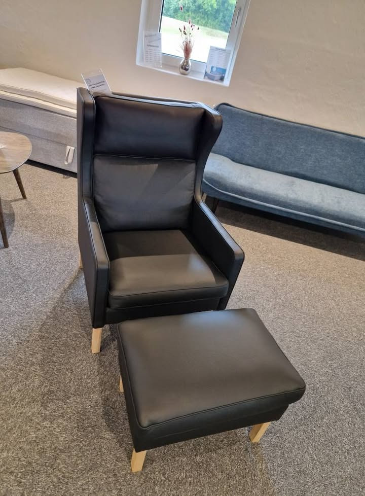 HOVELIND MØBLER tilbyder outlet rabat på smidt lænestol med skammel i sort læder