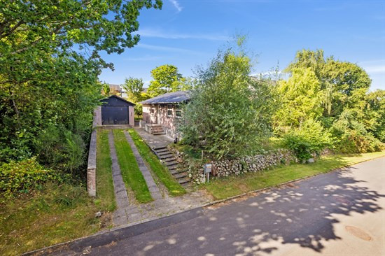 Villa med solrig terrasse, frodig have og lys åbent opholdsrum i tryg ramme