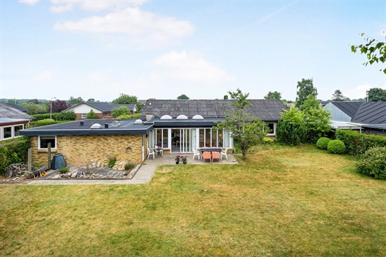 Velindrettet og rummelig gulstensvilla på rolig villavej – tæt på både skole, indkøb og fritidsaktiviteter