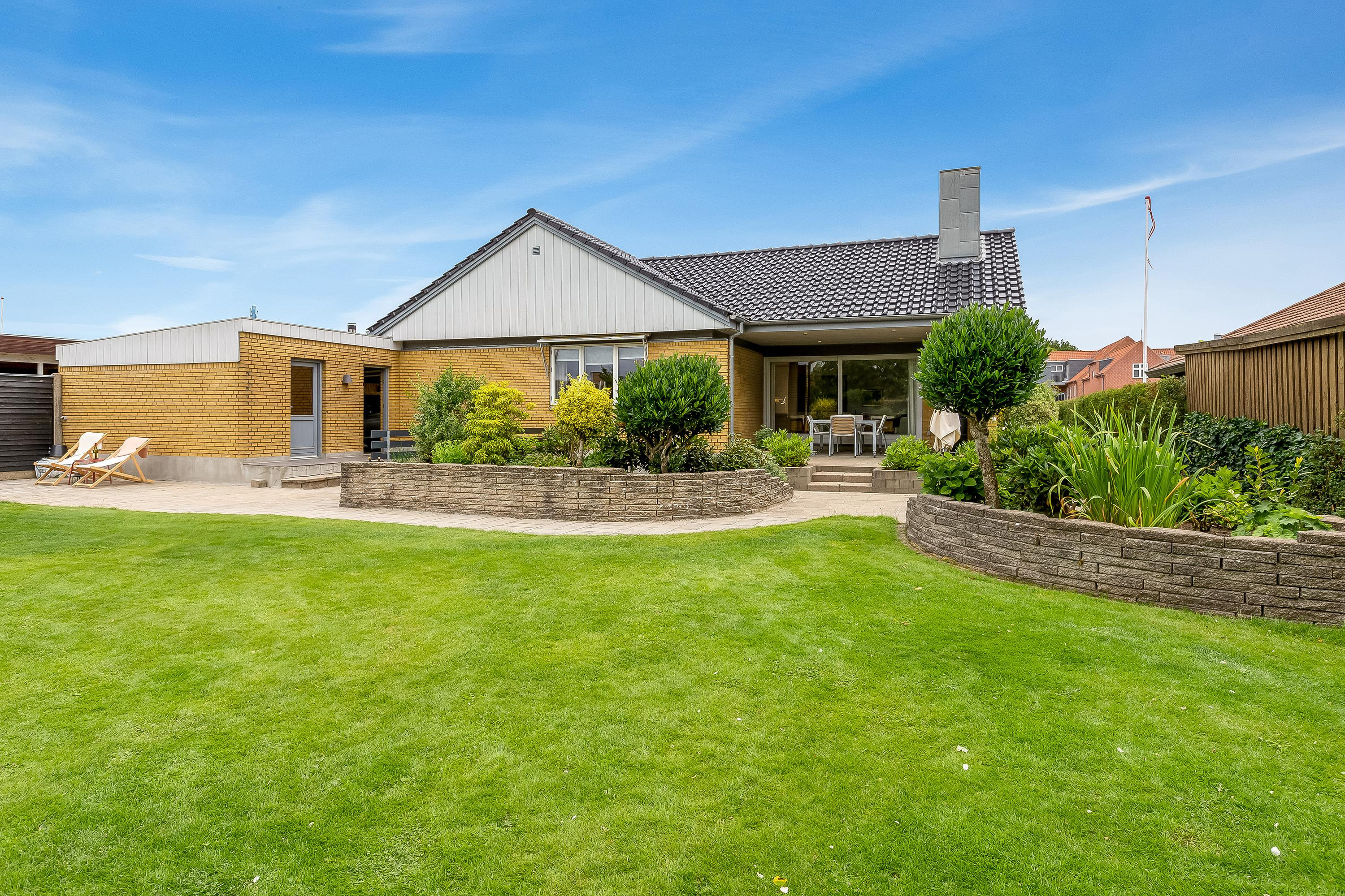 Charmerende Vinkelvilla i Lind: Dit Drømmehjem med Solrige Terrasser og Moderne Komfort