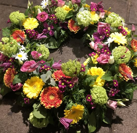 Fynbogården Blomster ApS viser en rundpyntet krans i glade farver