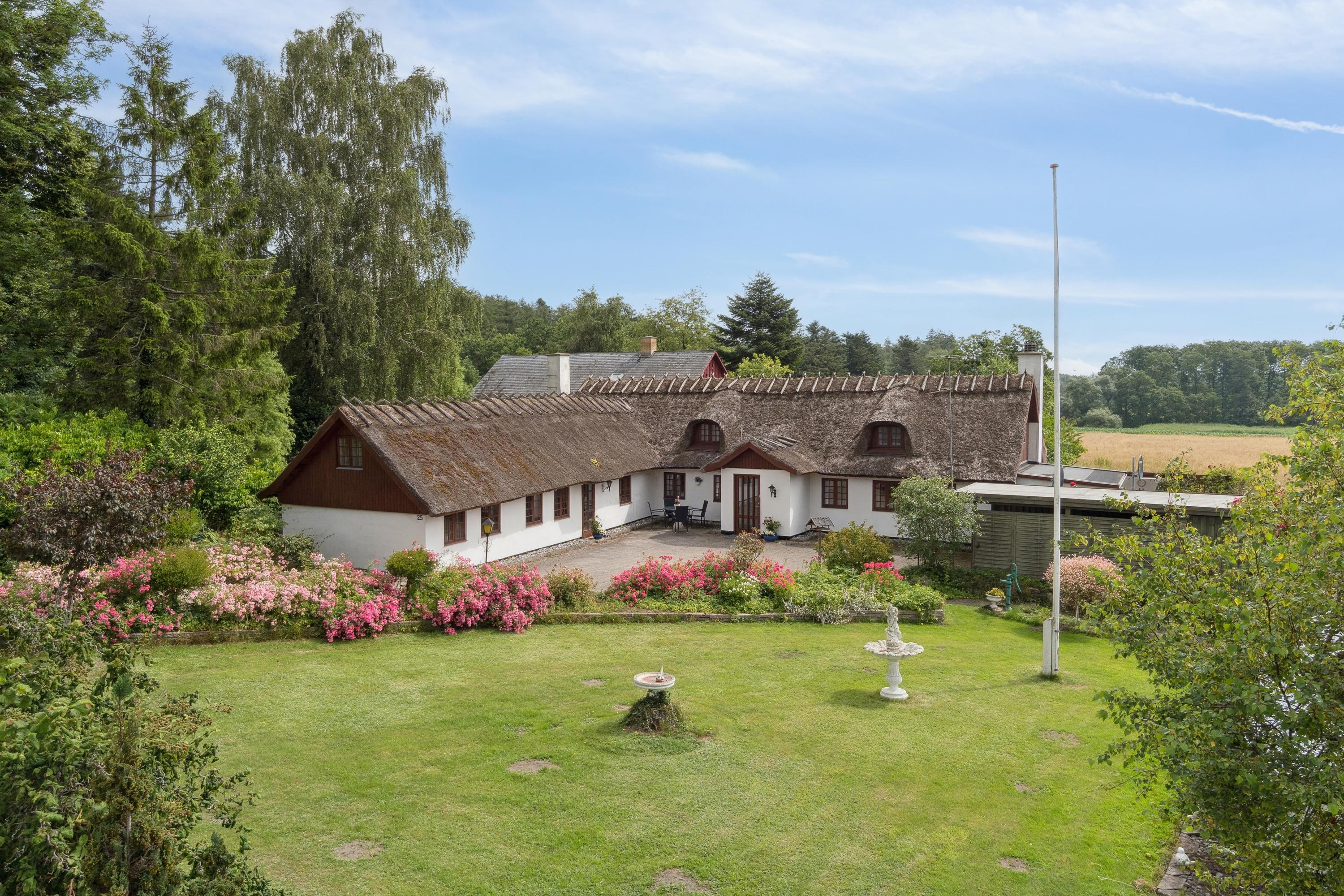 Idyllisk bindingsværksdrøm med stråtag og fredelige omgivelser