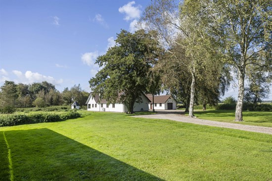Charmerende naturejendom i god stand med 8,3 ha jord og kun 1200 meter til vandkanten, ved en af områdets bedste badestrande.