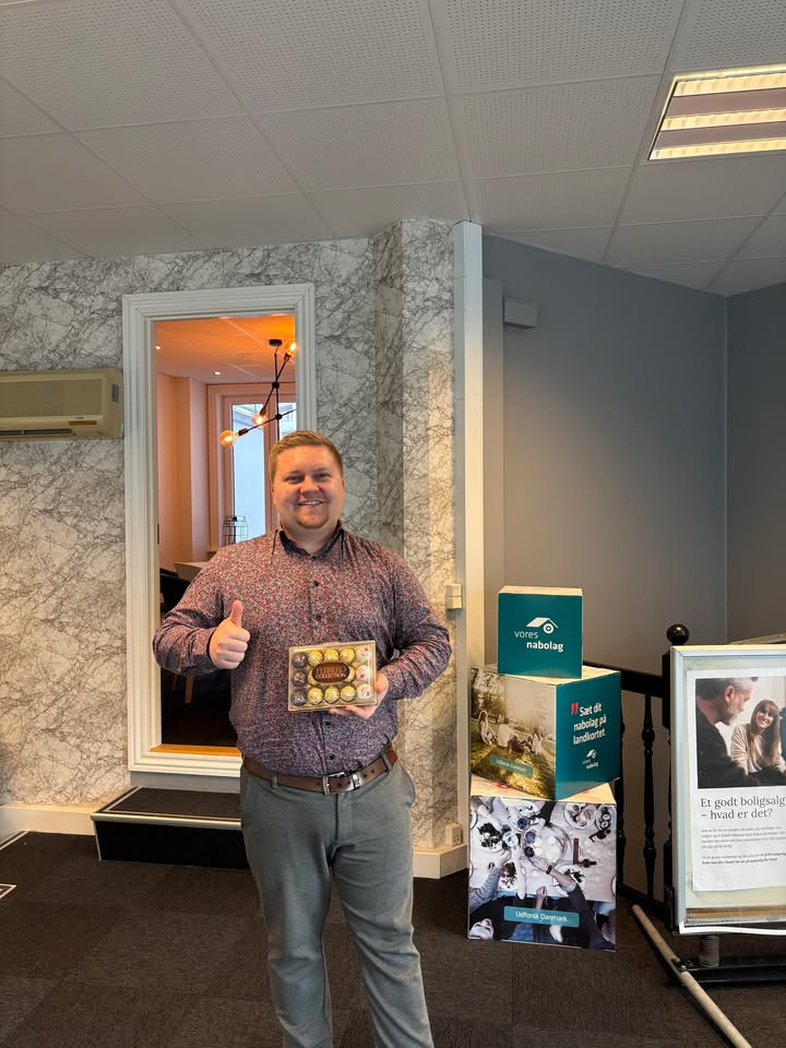 Glade kunder takker danbolig Nørresundby med chokolade for god behandling
