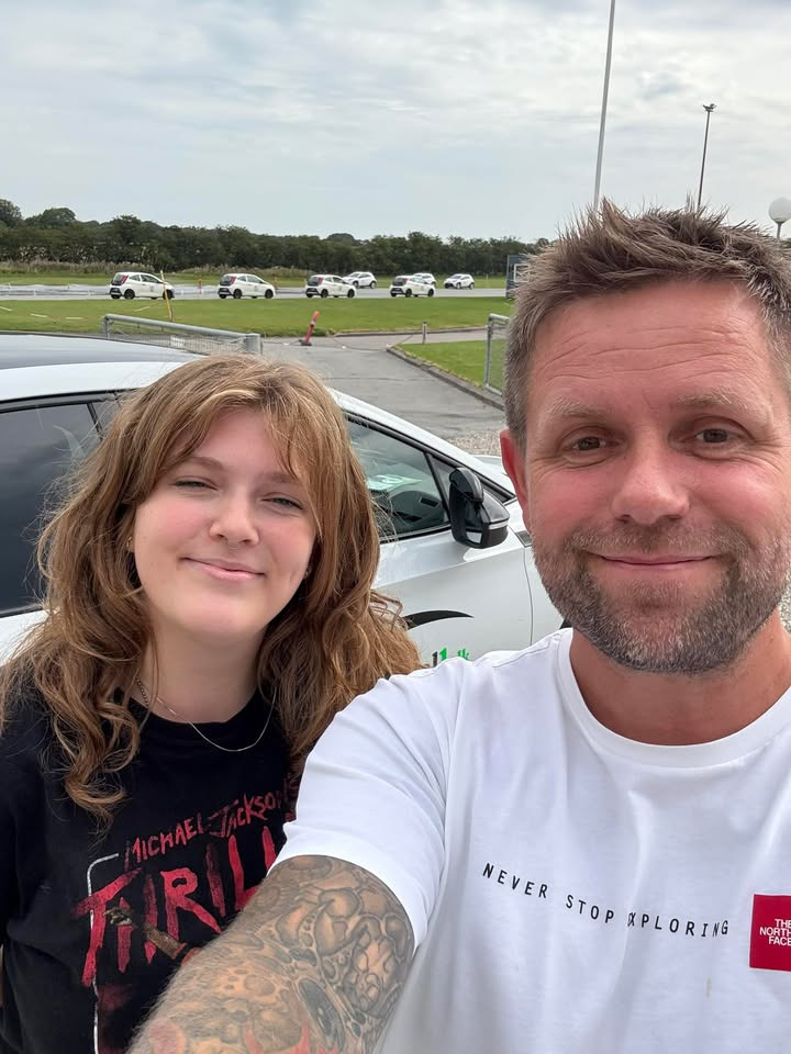 Frisdal Køreskole I/S lykønsker elev med kørekort og roser for høje standarder